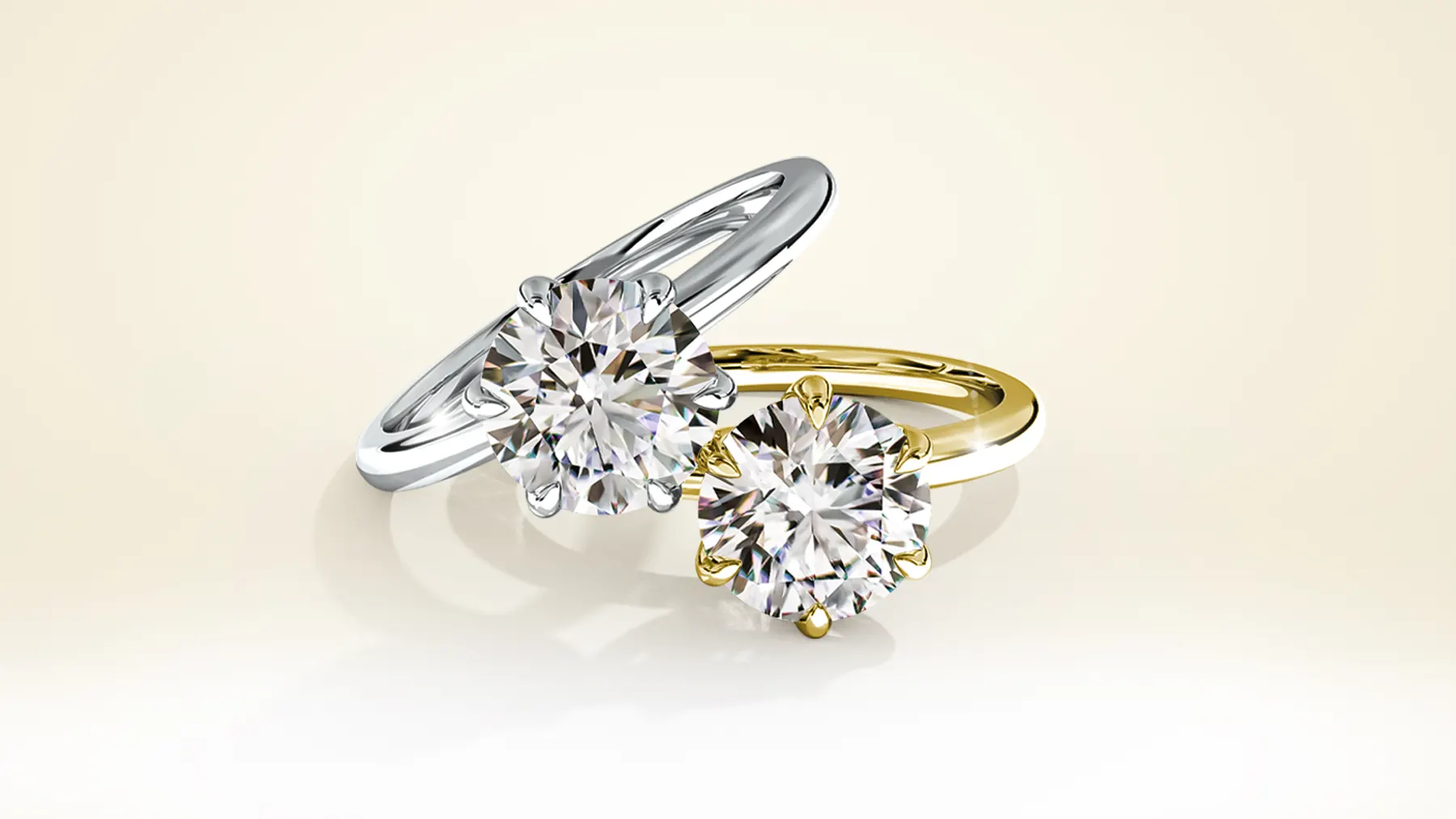 The same two solitaire rings rendered photorealistically in white gold and yellow gold, each with a round brilliant diamond